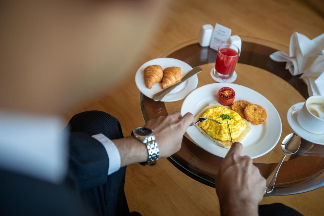 The Orchid Hotel Mumbai Vile Parle Exterior foto A man eating breakfast